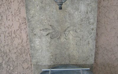 Une vasque sur la terrasse et un support d’arrosoirs.