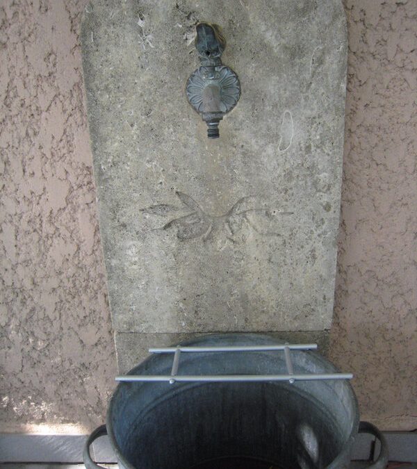 Une vasque sur la terrasse et un support d&rsquo;arrosoirs.