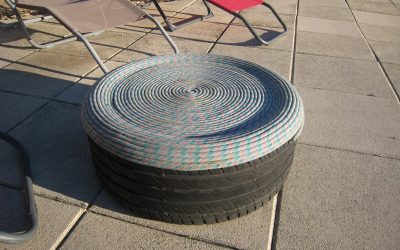 Un pouf avec un pneu usé et une corde d&rsquo;escalade usée